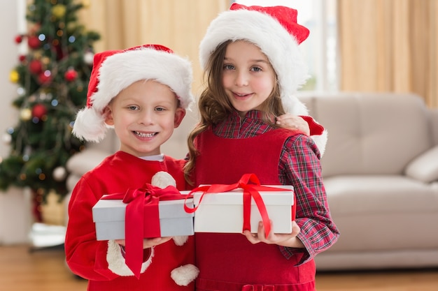 Piccoli fratelli festosi che tengono i regali