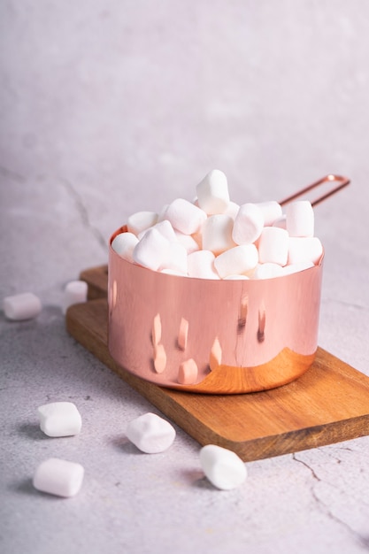 piccoli marshmallow bianchi in una casseruola di metallo rosa