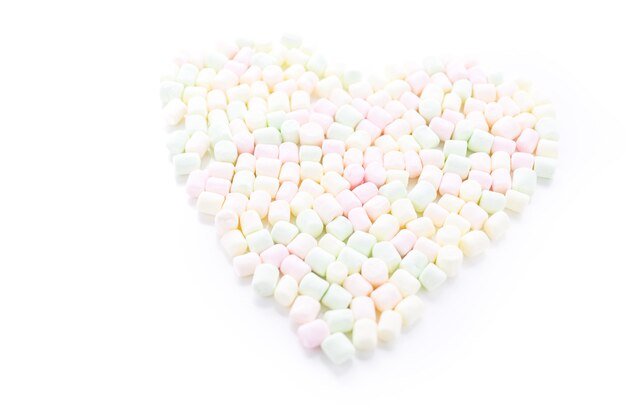 Piccoli marshmallow multicolori rotondi su un backgrouns bianco.