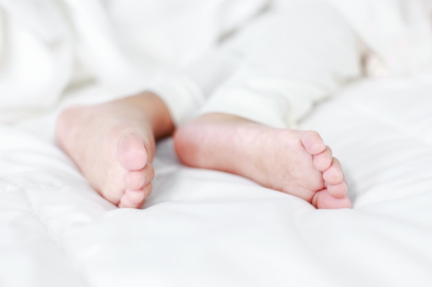 piccoli piedi del bambino sul letto