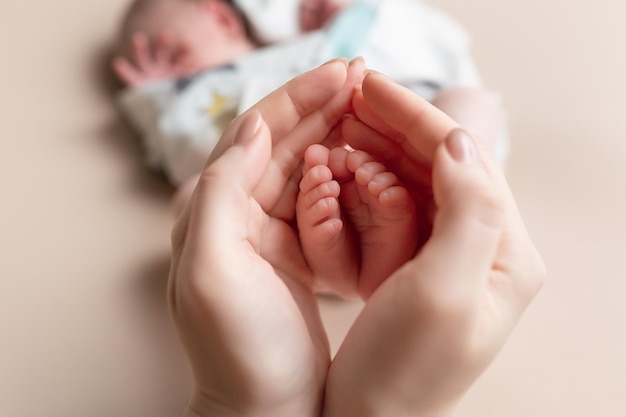 piccoli piedi di un neonato nelle mani della madre