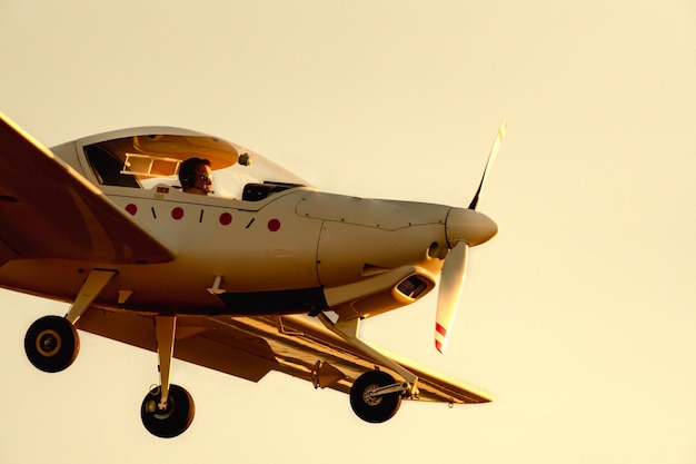 Piccolo aereo ad elica che atterra o decolla sulla pista dell'aeroporto di Sabadell con un cielo arancione