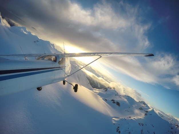 Piccolo aeroplano che sorvola il paesaggio montano canadese