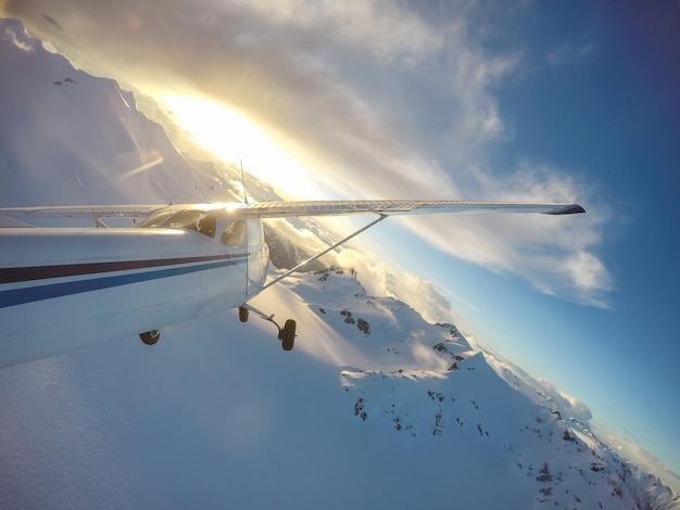 Piccolo aeroplano che sorvola il paesaggio montano canadese