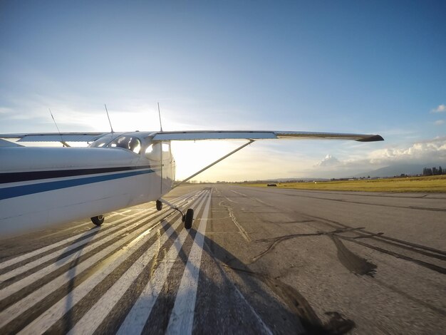 Piccolo aeroplano che toglie la pista durante un tramonto vibrante