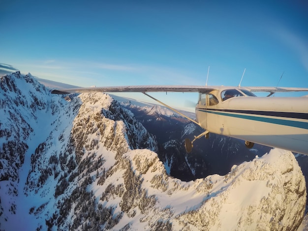 Piccolo aeroplano che vola vicino alle montagne rocciose di Candian