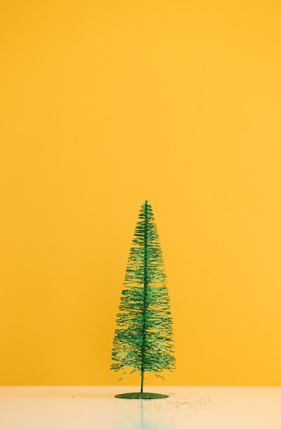 Piccolo albero di Natale su sfondo giallo