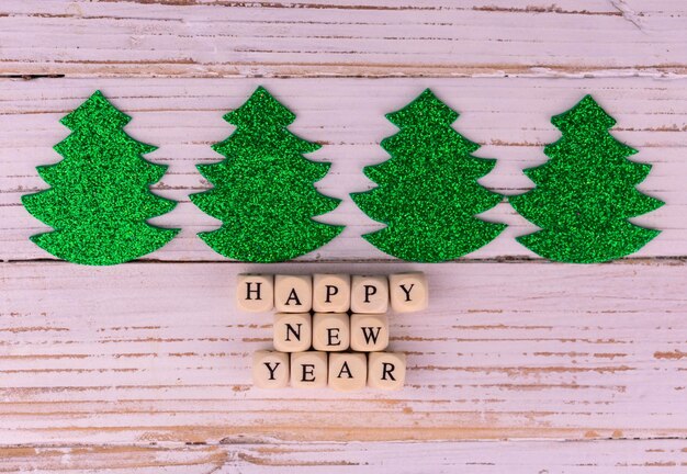 Piccolo albero di Natale verde su fondo di legno bianco