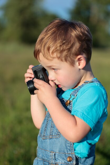 Piccolo bambino a scattare foto all&#39;aperto