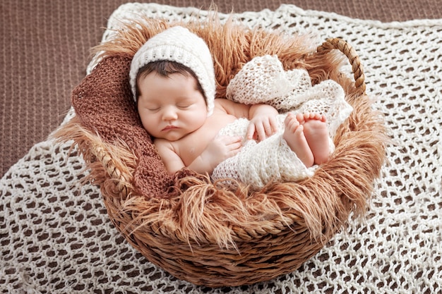 Piccolo bambino appena nato che dorme in un cestino