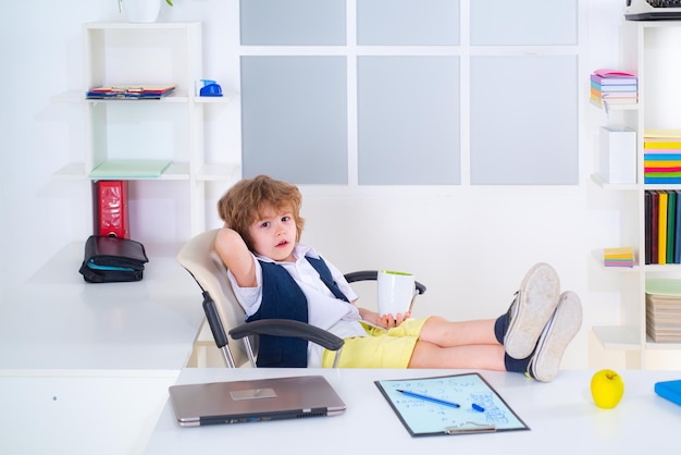 Piccolo bambino capo piccolo uomo d'affari che lavora in ufficio