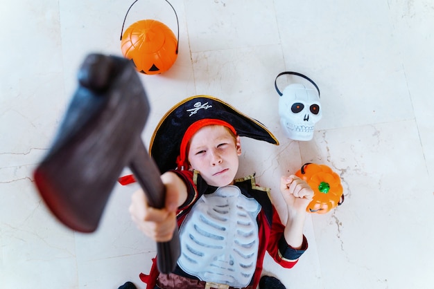 Piccolo bambino caucasico che gioca con il costume da pirata di Halloween a casa