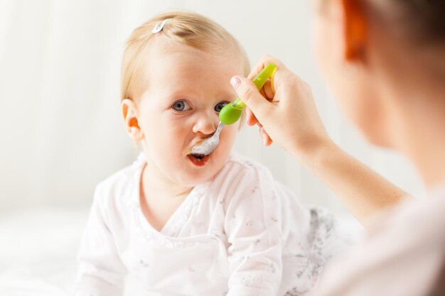 Piccolo bambino che allatta con un cucchiaio