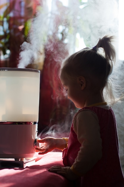 Piccolo bambino che gioca con l'umidificatore