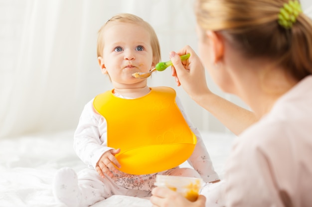 Piccolo bambino che si alimenta con un cucchiaio