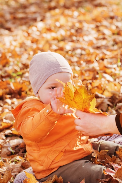 Piccolo bambino con la madre nel parco soleggiato di autunno