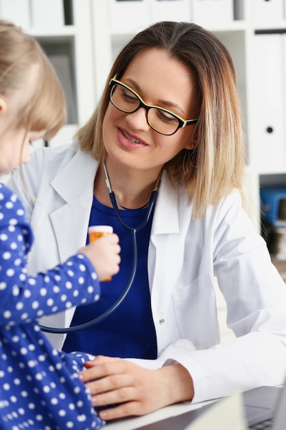 Piccolo bambino con stetoscopio alla reception del medico. Concetto rotondo di impulso della prova della clinica dello specialista di malattia del bambino del reparto di stile di vita sano sano del sussidio del bambino dell'infante del ritratto dell'esame fisico