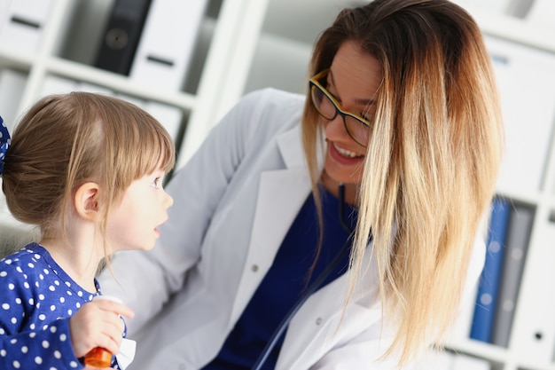 Piccolo bambino con stetoscopio alla reception del medico