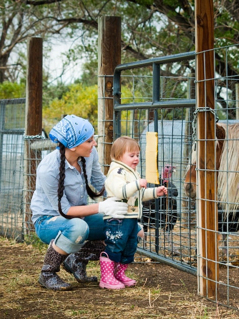 Piccolo bambino con sua madre in fattoria.