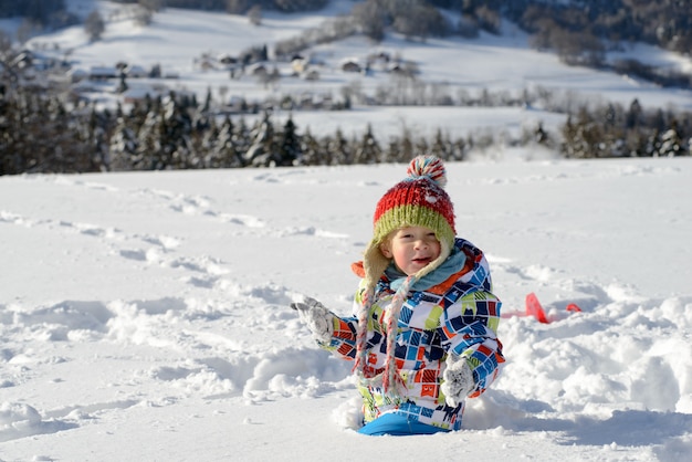 Piccolo bambino di 3 anni che gioca nella neve