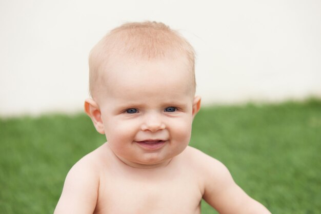 Piccolo bambino di sei mesi con gli occhi azzurri e biondo