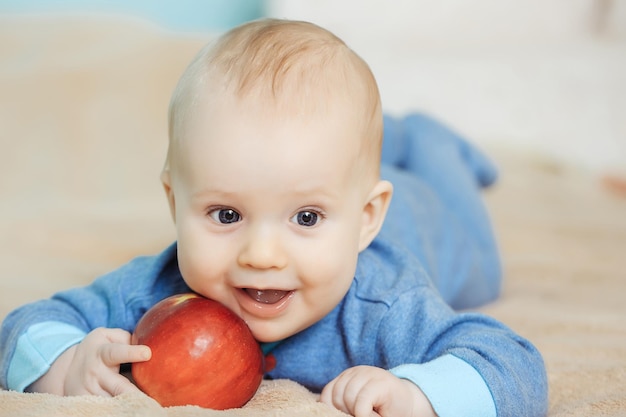 Piccolo bambino felice con mela rossa