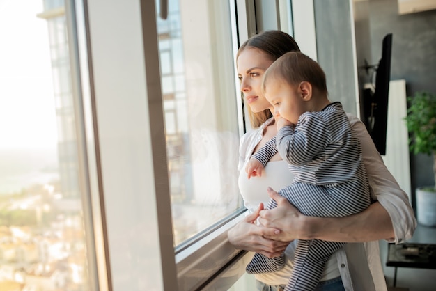 Piccolo bambino sorridente e felice con la mamma sul divano