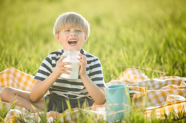 Piccolo bambino sveglio che beve latte fresco