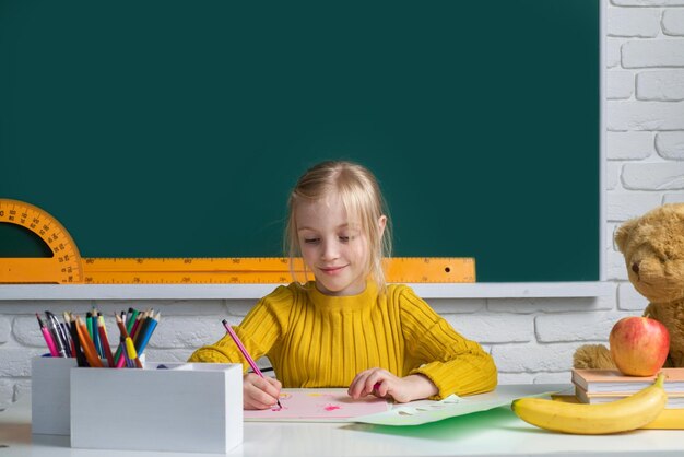 Piccolo bambino sveglio che studia in aula all'apprendimento della scuola elementare e al concetto di bambini