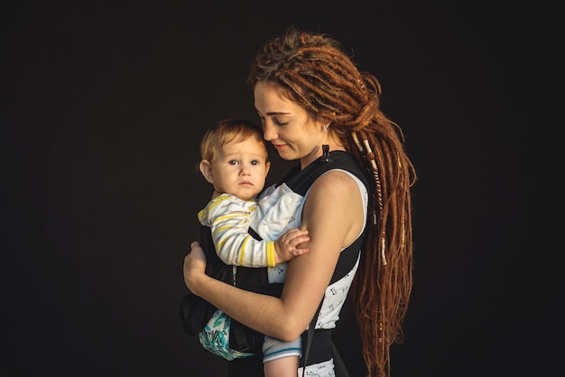 Piccolo bambino sveglio con sua madre moderna