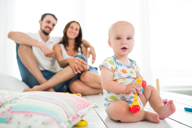 Piccolo bambino sveglio di sei mesi che gioca con i giocattoli