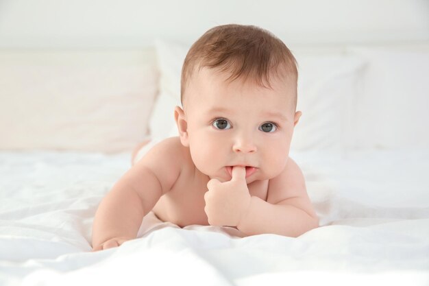 Piccolo bambino sveglio dopo il bagno sdraiato sul letto a casa