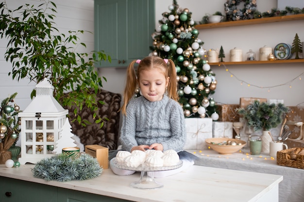 Piccolo bambino sveglio in cucina a casa di Natale.