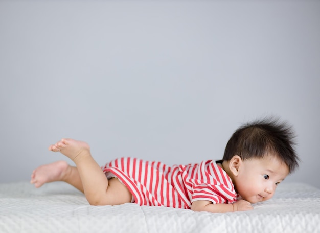 Piccolo bambino sveglio sul letto