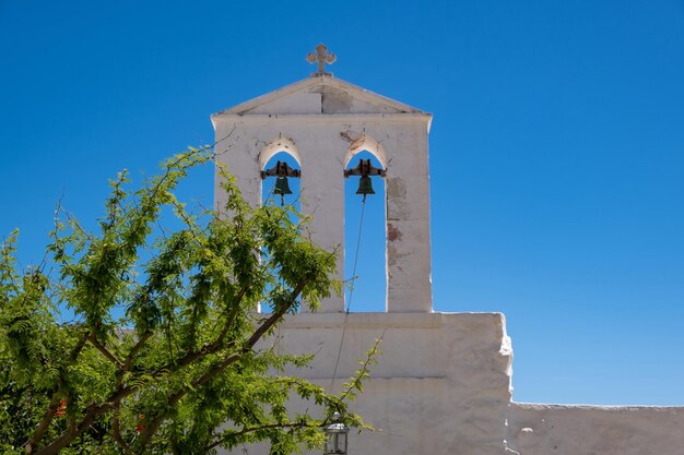 Piccolo campanile della chiesa dettaglio cappella di colore bianco su sfondo blu chiaro Grecia