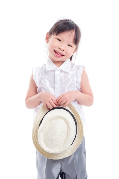 Piccolo cappello asiatico della holding della ragazza e sorrisi sopra priorità bassa bianca