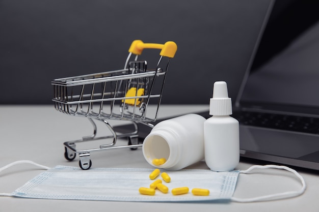 Piccolo carrello con il concetto di farmaci per l'acquisto online di farmaci