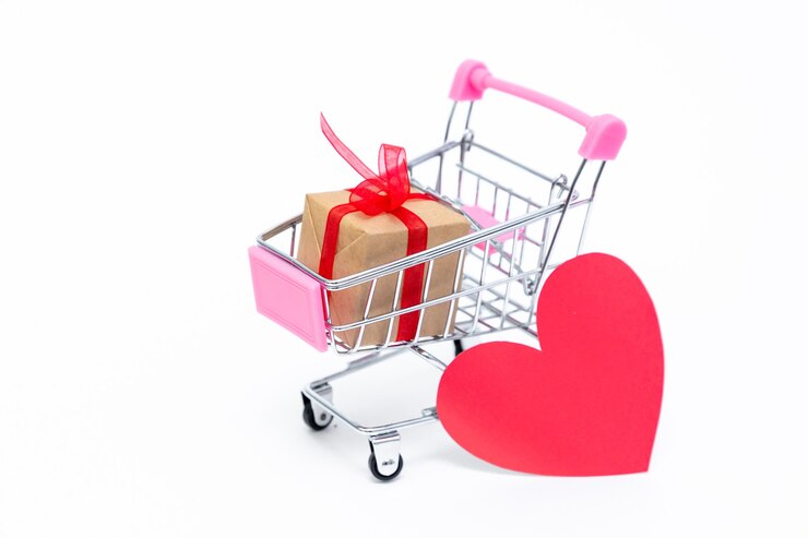 Piccolo carrello della spesa con confezione regalo sulla superficie bianca