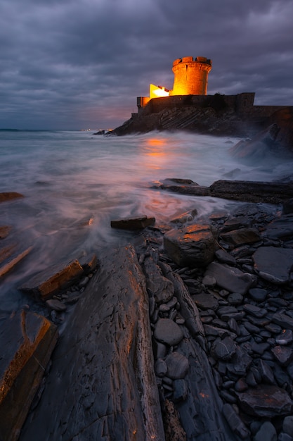 Piccolo castello circondato dal coraggioso Oceano Atlantico a Sokoa nella baia di Donibane Lohitzune nei Paesi Baschi.