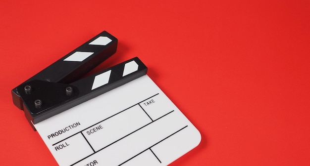 Piccolo clapperboard o ardesia cinematografica su sfondo rossouso nella produzione video e nell'industria cinematografica