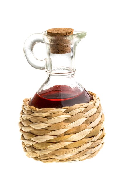 Piccolo decanter con aceto di vino rosso isolato sul bianco