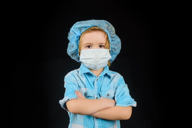 Piccolo dottore in maschera ragazzo carino in medicina maschera sanitaria bambino ragazzo con protezione maschera facciale covid