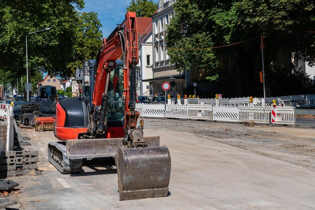 Piccolo escavatore rosso in piedi su un cantiere