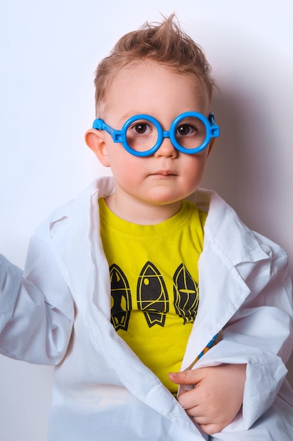 Piccolo esploratore Il ragazzo fa lo scienziato Bambino divertente con gli occhiali blu Foto colorata carina Dottore