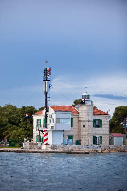 Piccolo faro in un ingresso della baia di Sibenik, Croazia. Colpo verticale