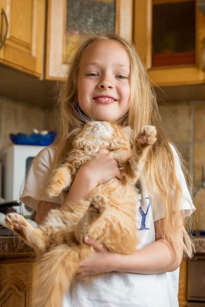 Piccolo gattino domestico persiano carino nella mano della ragazza Gatto e bambino a casa