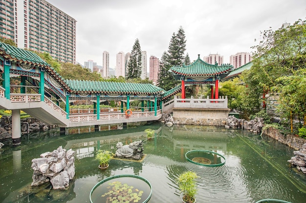 Piccolo laghetto nel giardino dei desideri di Dio tra i grattacieli della città nel tempio di Wong Tai Sin a Kowloon a Hong Kong
