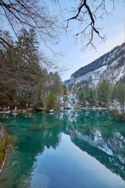 Piccolo lago di acque turchesi in un ambiente innevato noto come lago Blausee in Svizzera