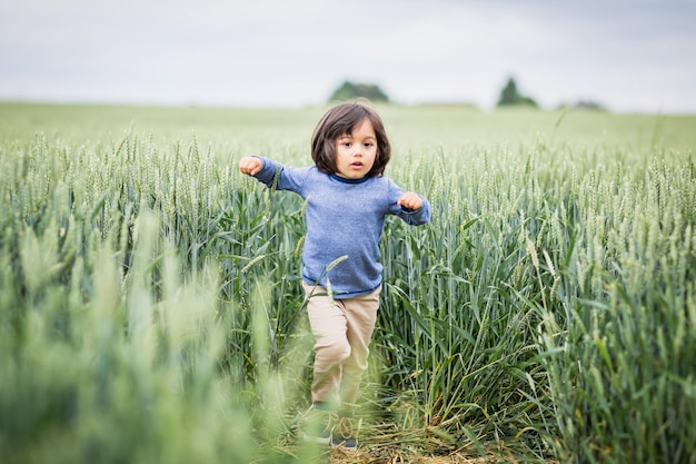 Piccolo neonato bello orientale che corre nel campo