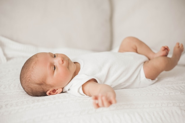 Piccolo neonato carino è sdraiato sul letto. Bambino.